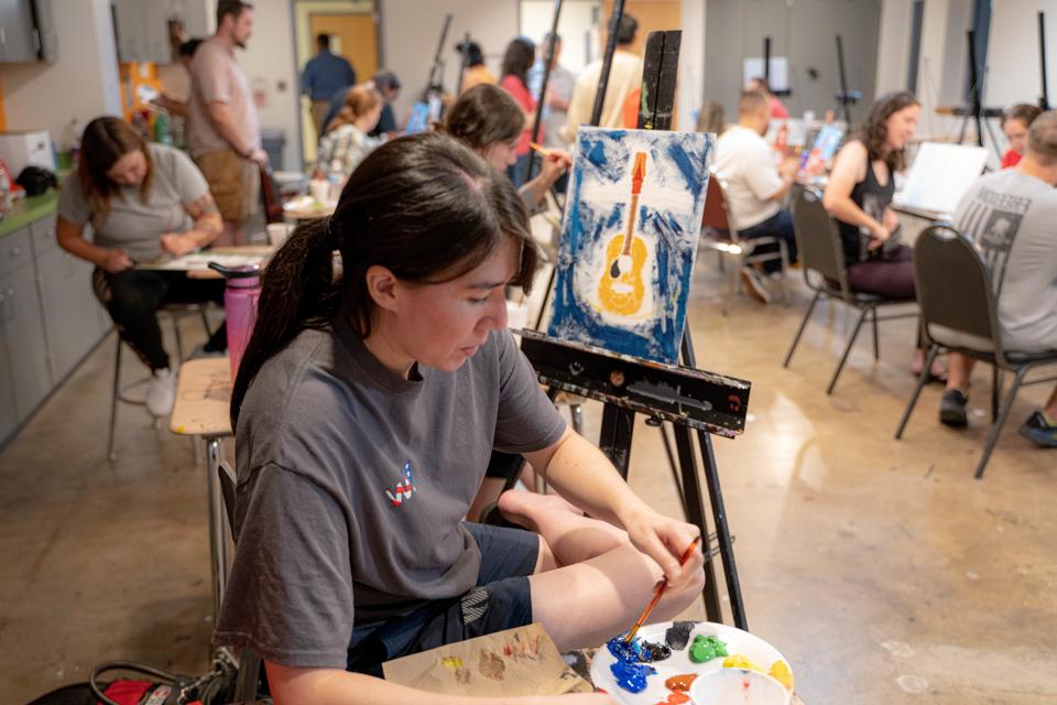 Female student veteran painting a canvas