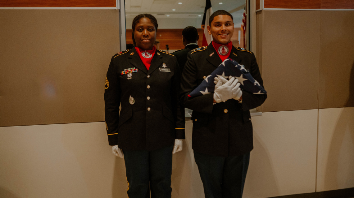 ROTC cadets standing with folded flag 